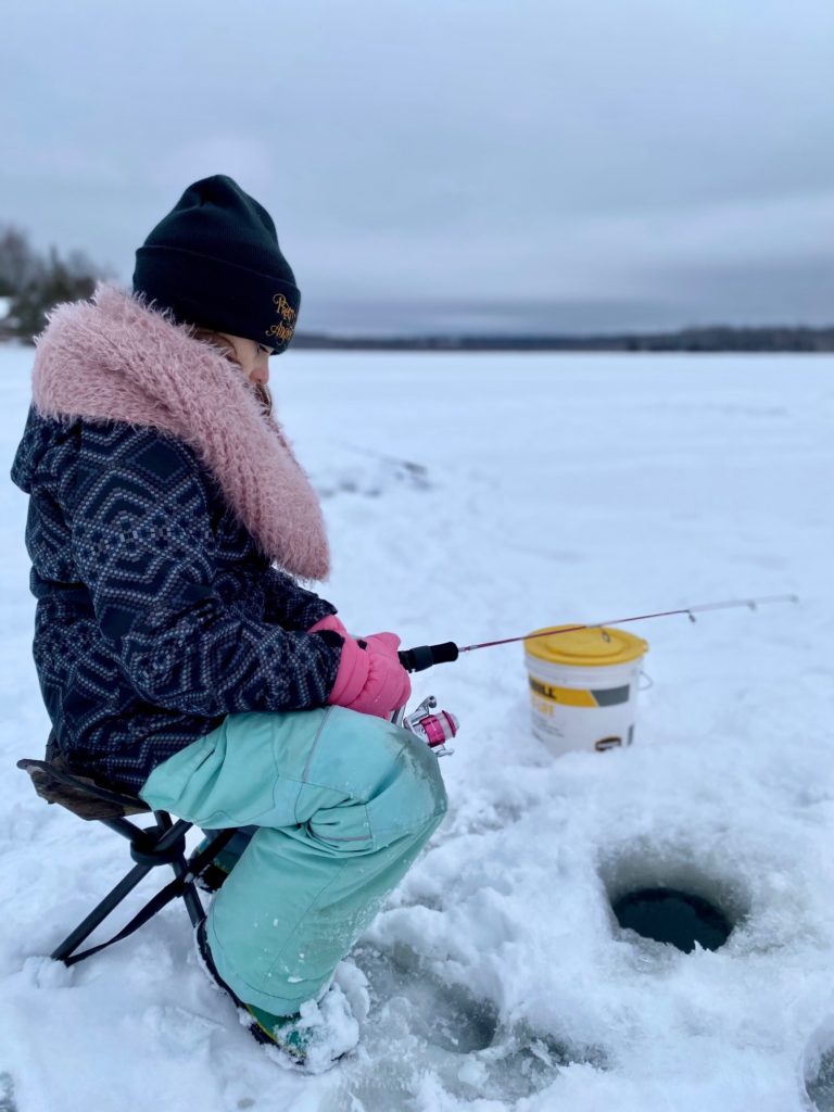 Young girl sitting on a chair ice fishing on the Bay of Quinte